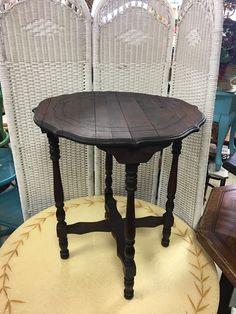 an old table is on display in a room with wicker chairs and caned walls