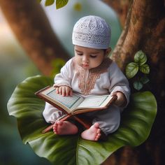 a baby sitting on a leaf reading a book