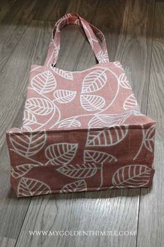 a pink and white bag sitting on top of a wooden floor