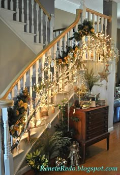 the stairs are decorated with christmas lights and greenery for decoration in this home's entryway