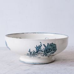 a blue and white bowl sitting on top of a marble counter next to a wall