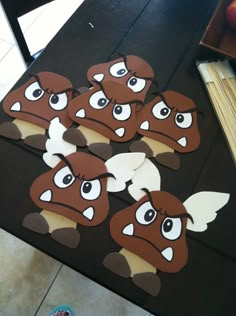 some brown and white paper cut outs on a black table with an apple in the background