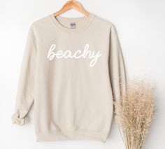 Whether you are taking a sunset stroll on the beach or lounging at home, this beachy sweatshirt will bring you pure comfort.  This unisex heavy blend crewneck is made from polyester and cotton, helping the design come out looking fresh and beautiful. The collar is ribbed knit, so it retains its shape even after washing. There are no itchy side seams on these sweaters. 50% Cotton 50% Polyester Medium-heavy fabric Unisex sizes (See size chart.) Sewn in label Available in 4 colors. Explore all Summ Trendy Summer Beach Sweatshirt, Trendy Beach Sweatshirt For Summer, Long Sleeve Sweatshirt For Beach Season, White Summer Sweatshirt For Beach, Beach Long Sleeve Sweatshirt, Spring Beach Cotton Sweatshirt, Beach Season Long Sleeve Sweatshirt, Casual Beach Sweatshirt, Casual Summer Beach Sweatshirt