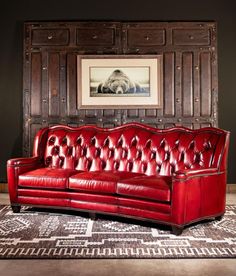 a red leather couch sitting on top of a rug