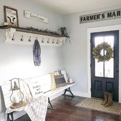 a white bench sitting in the middle of a room next to a black front door