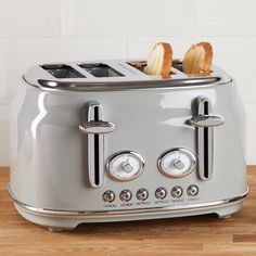 a toaster with two slices of bread on it sitting on a wooden counter top