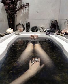 a person laying down in a bathtub with their feet on the edge