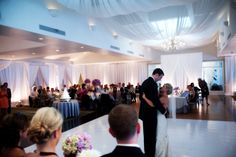 a bride and groom are sharing their first dance at the wedding reception in front of an audience