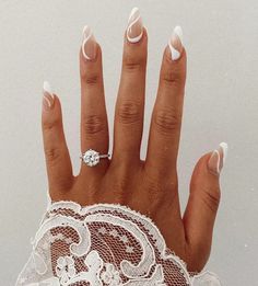 a woman's hand with white nail polish and an intricate lace gauzette