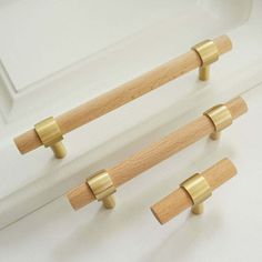 two wooden handles on the side of a white cabinet