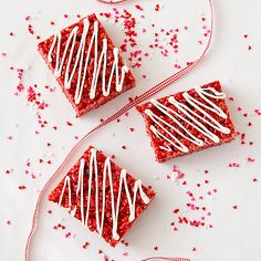 three pieces of red velvet cake with white icing on them and sprinkles