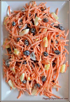 carrot salad with raisins and apples on a white plate