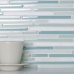 a cup and saucer sitting on top of a counter next to a tiled wall