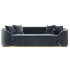 a blue velvet couch with gold trimmings and two pillows on top of it