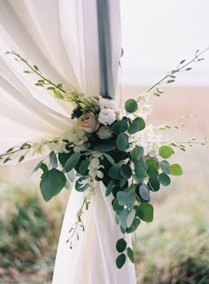 a wedding arch decorated with greenery and flowers