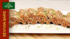 several pieces of food on a white plate with green sprinkles and seasoning