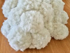 a pile of white wool sitting on top of a wooden floor