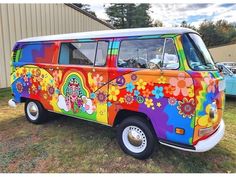 an old vw bus painted with flowers and rainbow colors