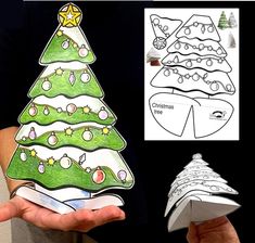 a person holding up a paper christmas tree