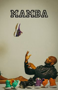 a man is sitting on the floor with his feet up in front of him and shoes flying through the air