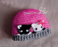 there is a crocheted hat with two cats on it