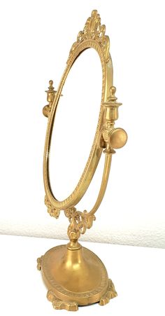 an ornate gold mirror on top of a stand