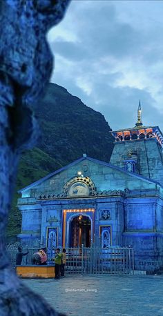 a large blue building sitting on top of a lush green hillside