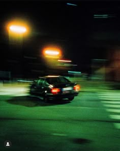 a car driving down the street at night