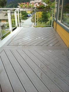 a wooden deck with railings and windows