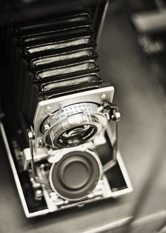 an old fashioned camera sitting on top of a table