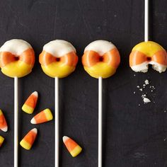 several candy lollipops with white frosting and candy candies on them