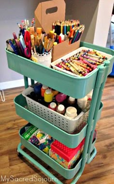 a cart filled with lots of different colored pencils and markers on top of a hard wood floor