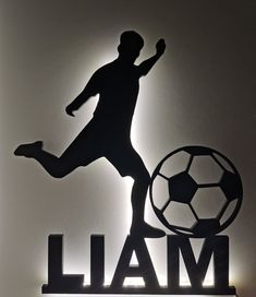 the silhouette of a man kicking a soccer ball on top of a sign that says i am