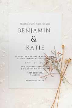 a white wedding card with dried flowers on it