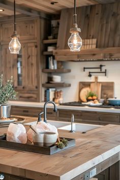 a kitchen with wooden cabinets and lights hanging from the ceiling, along with an island