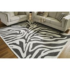 a living room area with two couches and a zebra rug