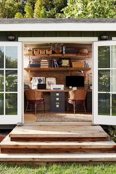 a small home office is built into the side of a house with sliding glass doors