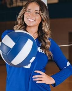 a woman is smiling while holding a volleyball