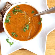 a bowl of soup with bread on the side