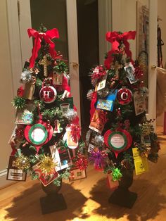 two christmas trees decorated with ornaments and ribbons