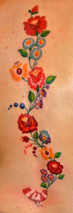 a woman's back with flowers painted on her stomach and the word love written in it