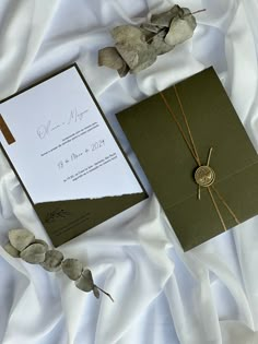 the wedding stationery is laid out on white sheets