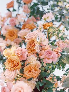 a vase filled with lots of pink and yellow flowers