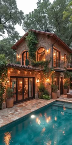 a house with a pool in front of it and lots of greenery on the outside