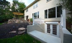 an outside view of a house with steps leading up to the front door and patio area