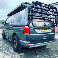 the back end of a green van parked in a parking lot