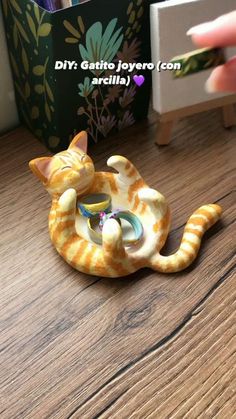 a yellow and white cat figurine sitting on top of a wooden table