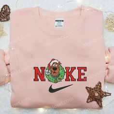 Introducing the Nike x Scooby Doo Christmas Wreath Embroidered Sweatshirt, a perfect blend of festive cheer and athletic style. This limited-edition sweatshirt showcases a meticulously crafted wreath embroidered with iconic Nike and Scooby Doo elements. Made with premium materials, it offers exceptional comfort and durability. With its unique design, this sweatshirt is a standout piece [...] Nike Inspired, Grinch Hand, Pink Coffee Cups, Maroon Hoodie, Embroidered Shirts, Shirt Nike, Nike Brand, Custom Nikes, Disney Shirt