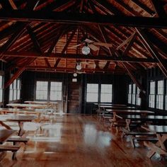 an empty room with tables and benches in the center, all made out of wood