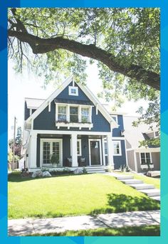 a blue house with white trim and windows on the front porch is surrounded by green grass